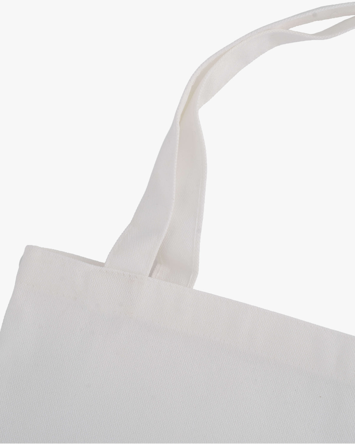 Nahaufnahme der Trägerbefestigung an einer weißen Stofftasche mit robuster Naht.