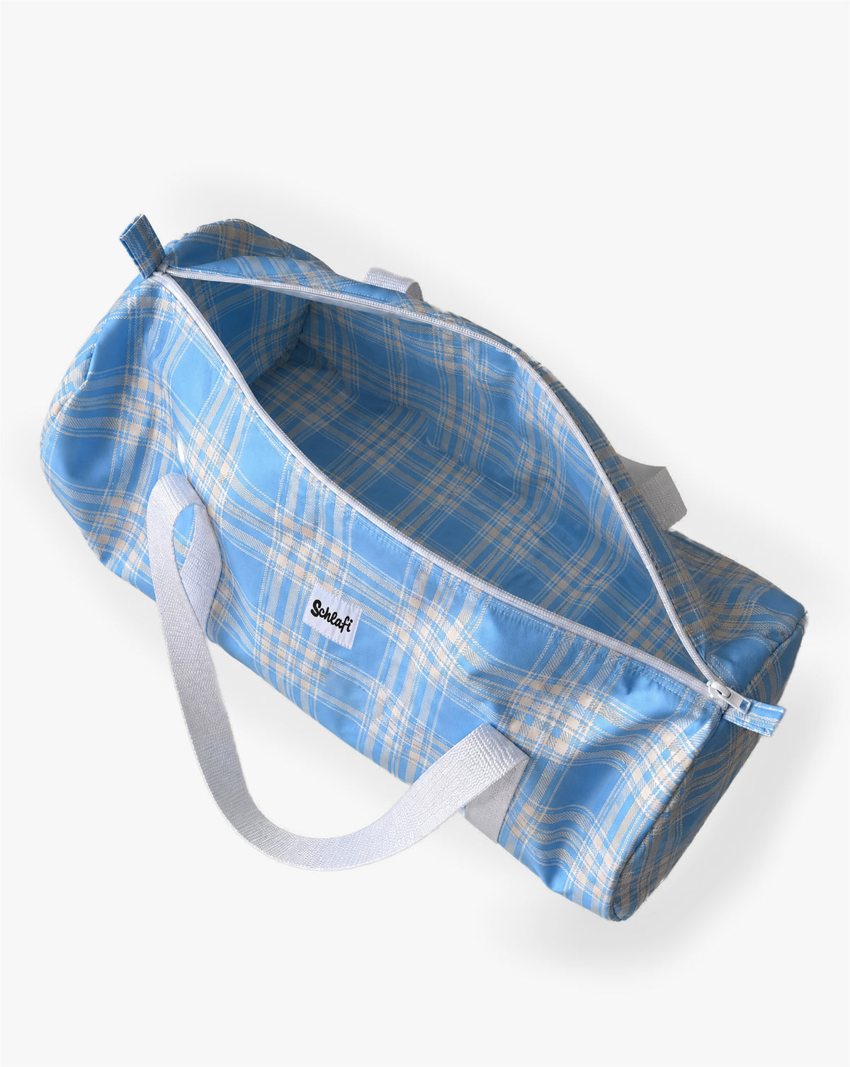 Hellblaue zylinderförmige Reisetasche mit weißem Karomuster, weißen Tragegriffen, Reißverschluss und kleinem Schlafi-Logo auf der Vorderseite.